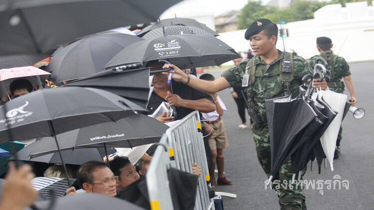 ทหารนำร่มมาให้ประชาชน ก่อนเข้ากราบสักการะพระบรมศพ ร.9
