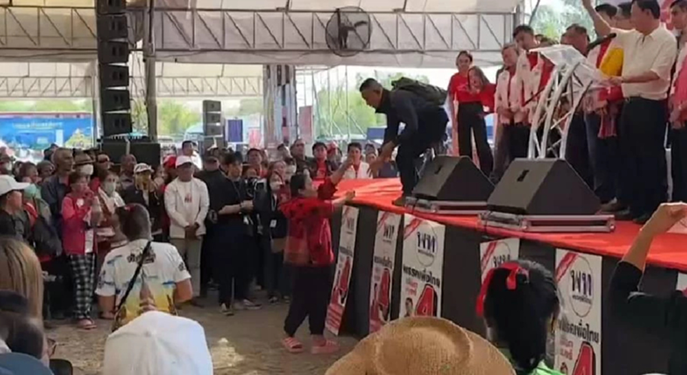 'สตรีเสื้อแดง' ปาสิ่งของประจาน 'ทักษิณ' กลางเวทีปราศรัย จ.มหาสารคาม
